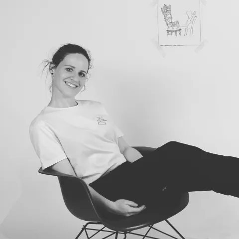 Foto von Rebecca Dold. Sie sitzt in einem Eamesstuhl.